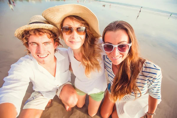 Gruppo di giovani felici che si fanno selfie sulla spiaggia — Foto Stock