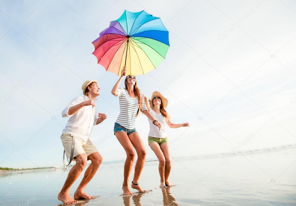 Group of happy young people having fun on the beach