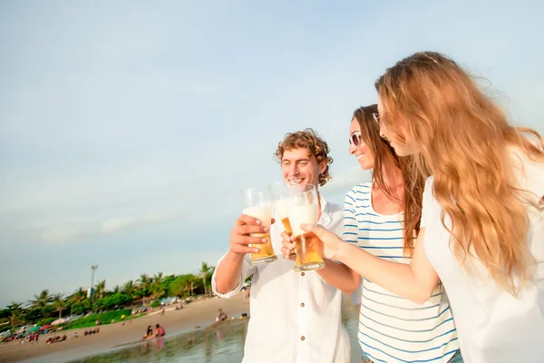 Gruppo di giovani felici che bevono birra sulla spiaggia — Foto Stock