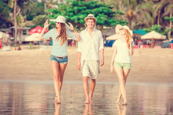 Grupp glada ungdomar gå längs stranden på vackra sommar solnedgång — Stockfoto