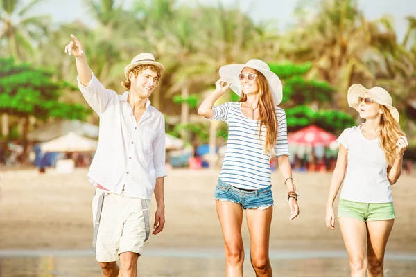 Grupp glada ungdomar gå längs stranden på vackra sommar solnedgång — Stockfoto