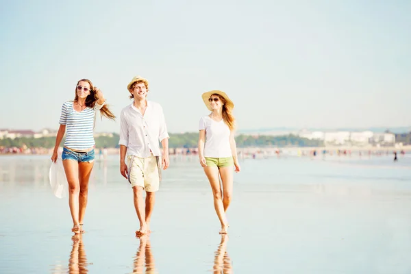 Grupa szczęśliwych ludzi młodych spaceru wzdłuż plaży na lato piękny zachód słońca — Zdjęcie stockowe