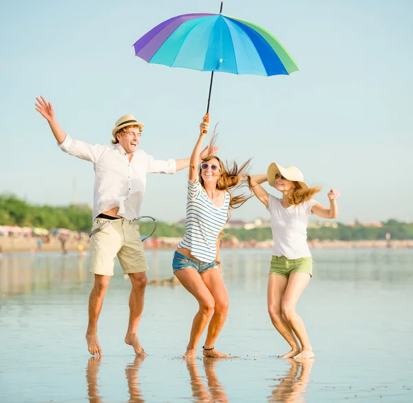 Группа счастливых молодых людей, веселящихся на пляже — стоковое фото