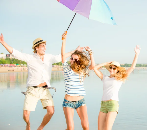 Bir grup mutlu genç sahilde eğleniyor. — Stok fotoğraf