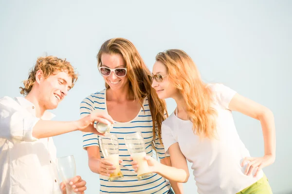 Group of happy young people drinking beer on the beach — Stock Photo, Image