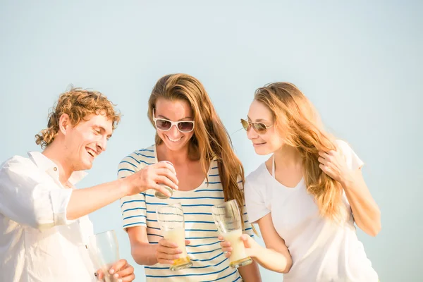Grupo de jovens felizes bebendo cerveja na praia — Fotografia de Stock