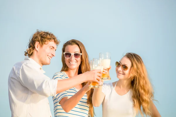 Grupo de jovens felizes bebendo cerveja na praia — Fotografia de Stock