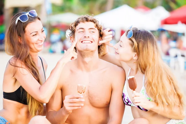 Grupo de jovens felizes comendo sorvete na praia — Fotografia de Stock