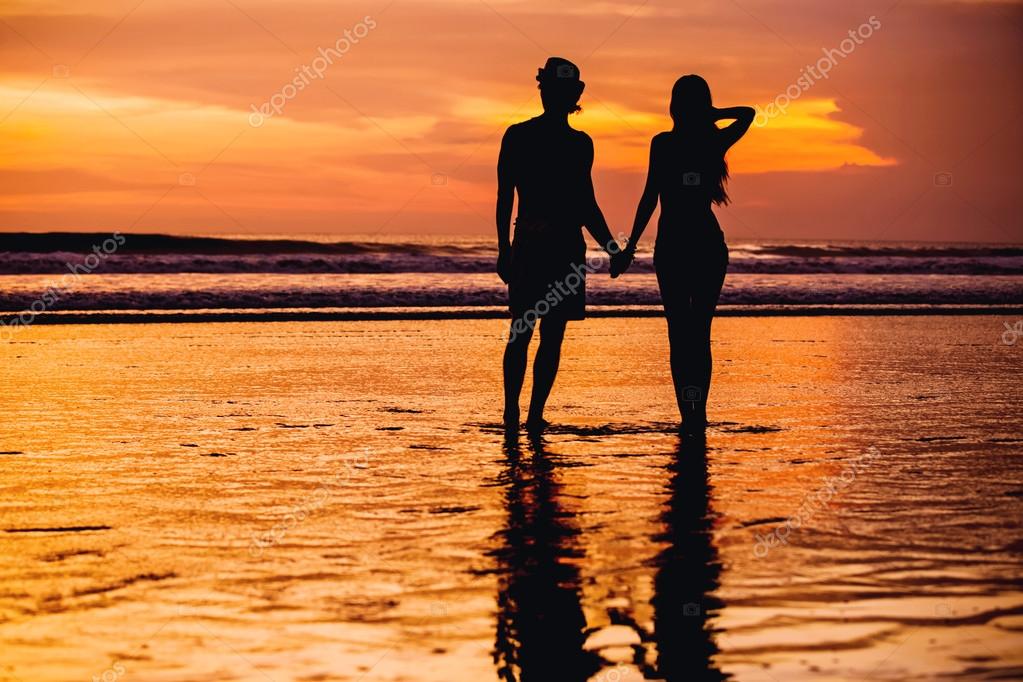 Silhouettes De Jeune Couple Amoureux Staing Sur La Plage Avec Beau Coucher De Soleil Rouge Comme