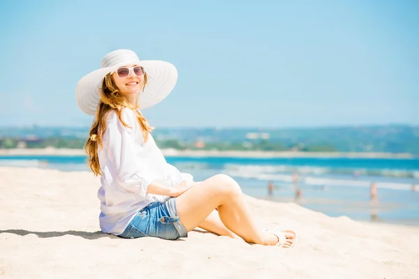 Trzymać młoda kobieta, leżąc na plaży w słoneczny dzień enjoing wakacji — Zdjęcie stockowe