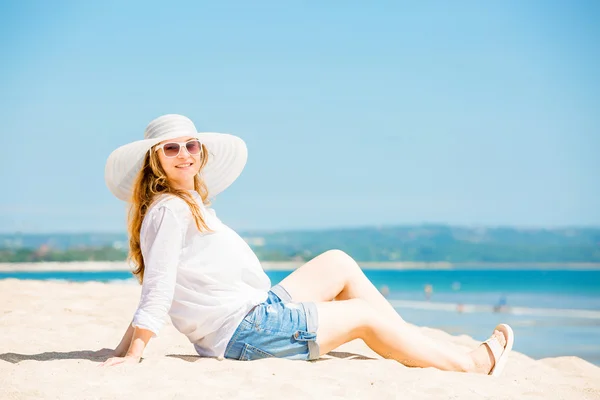 Trzymać młoda kobieta, leżąc na plaży w słoneczny dzień enjoing wakacji — Zdjęcie stockowe