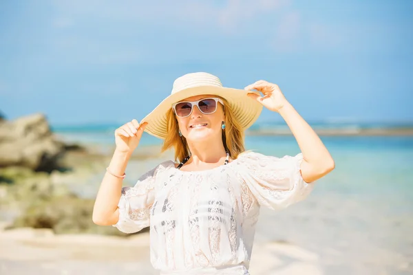 Buntes Porträt eines jungen hübschen Mädchens am Strand mit blauem Himmel auf dem Hintergrund. Reise, Urlaub, Paradieskonzept — Stockfoto
