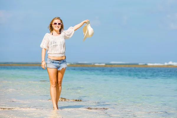 Sıska beyaz kız plajda mavi gökyüzü ve saf okyanus su arka plan üzerinde beyaz şapka ile sallayarak. seyahat, tatil, cennet kavramı, boşaltmak — Stok fotoğraf