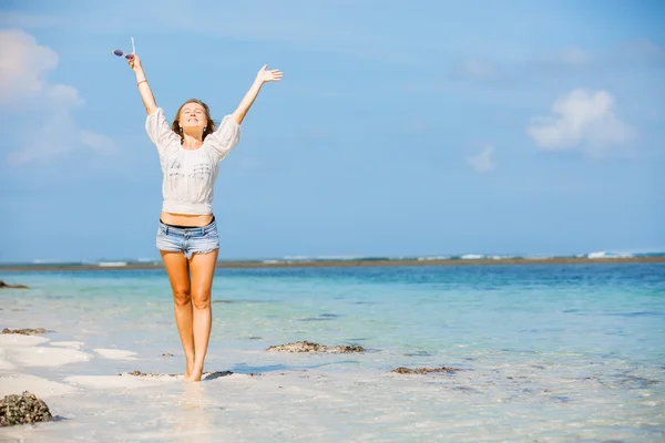 Joven flaco chica caucásica en la playa ondeando sobre el cielo azul y agua pura del océano en el fondo. Viajes, vacaciones, concepto de paraíso, copyspace —  Fotos de Stock