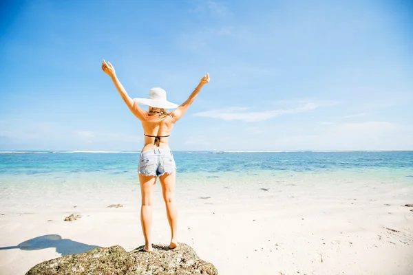 Unga kaukasiska skinny girl med tan stannar på rock som vetter mot havet mot blå himmel och rent vatten. resor, semester, paradise koncept, copyspace — Stockfoto