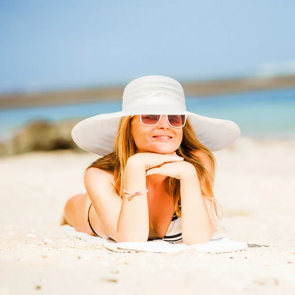 Sexual happy blond girl with sunglasses and white hat take sunbath on the beach enjoying summer holidays. Travel, vacation, lifestyle concept. Squared — Stock Photo, Image
