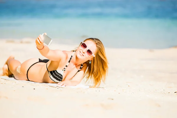 Sexy happy blond young female in sunglasses taking selfie on the beach enjoying summer holidays. Travel, vacation, lifestyle concept — Stock Photo, Image