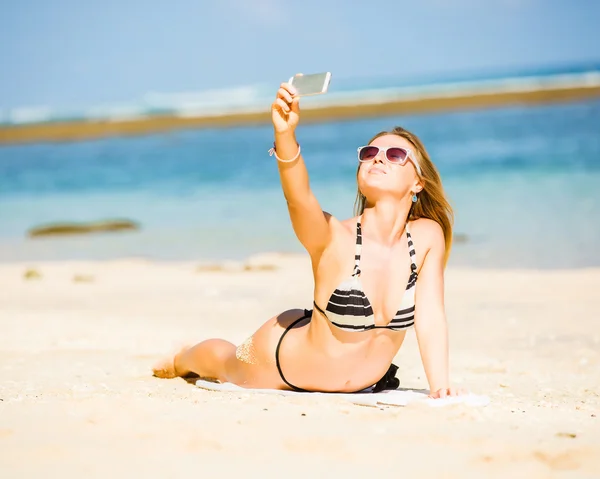 Sexy happy blond young female in sunglasses taking selfie on the beach enjoying summer holidays. Travel, vacation, lifestyle concept — Stock Photo, Image