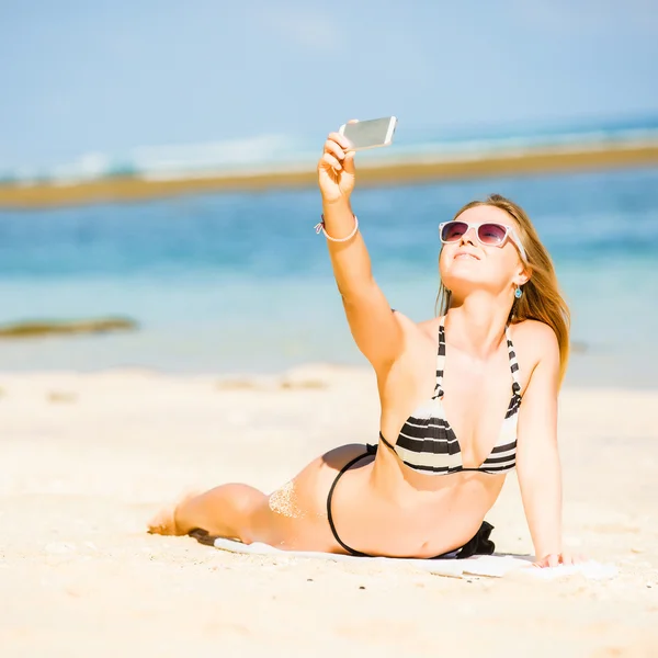 Sexy happy blond young female in sunglasses taking selfie on the beach enjoying summer holidays. Travel, vacation, lifestyle concept — Stock Photo, Image