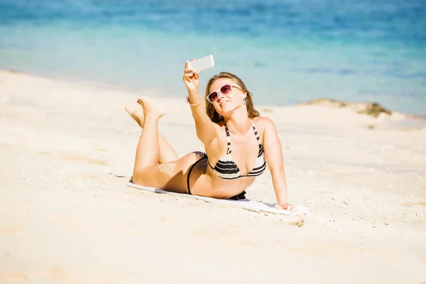Sexy happy blond young female in sunglasses taking selfie on the beach enjoying summer holidays. Travel, vacation, lifestyle concept — Stock Photo, Image