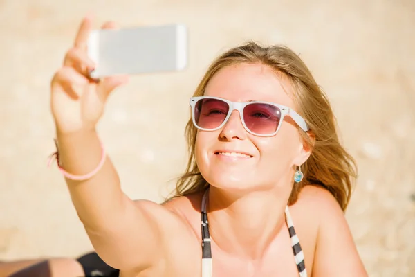 Sexy happy blond young female in sunglasses taking selfie on the beach enjoying summer holidays. Travel, vacation, lifestyle concept — Stock Photo, Image