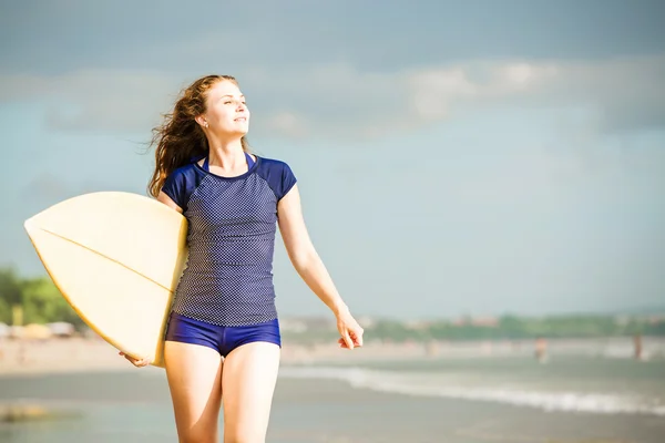 Beautiful sexy surfer girl on the beach at sunset walks along ocean shore, yellow surfboard in her hands. Healthy life, sport  concept with copyspace — Stock Photo, Image