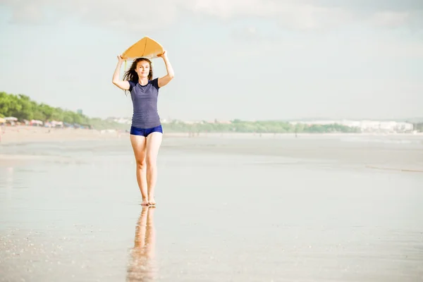 Dziewczyny piękne sexy surfer na plaży przy zachodzie słońca spacery wzdłuż brzegu oceanu, żółty desek surfingowych w jej ręce. zdrowego stylu życia, sportu koncepcja lato — Zdjęcie stockowe