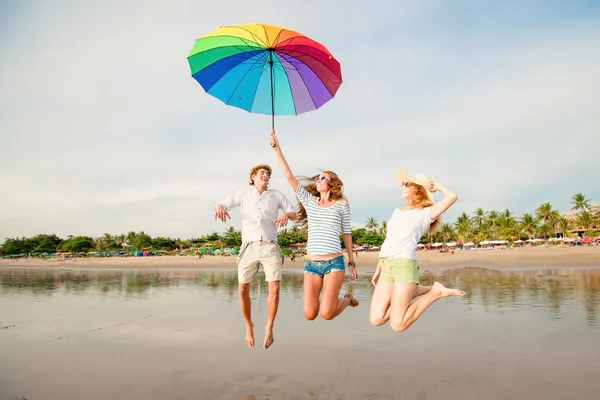 Группа счастливых молодых людей, веселящихся на пляже — стоковое фото