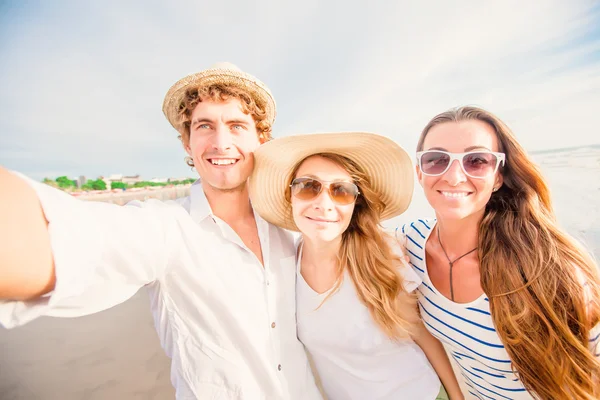 Gruppo di giovani felici che si fanno selfie sulla spiaggia — Foto Stock