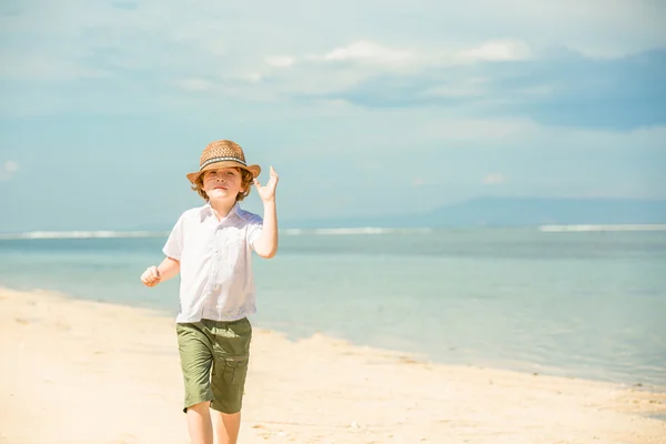 Portret szczęśliwy czerwonych włosach dziecko chłopca w hipster okulary przeciwsłoneczne i kapelusz lato cieszyć się życiem na plaży — Zdjęcie stockowe