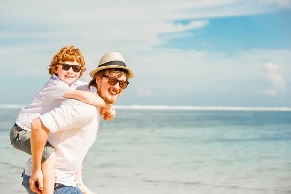 Csípő apa szakáll- és vörös hajú fiú, miután boldog nyári időszakban egy napsütéses napon a nyaralás napszemüveget visel. családi, hapiness, utazási koncepció — Stock Fotó