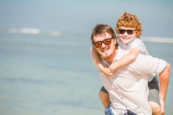 Hipster padre con la barba y el hijo pelirrojo con gafas de sol que tienen tiempo feliz verano en un día soleado de vacaciones. Familia, felicidad, concepto de viaje — Foto de Stock