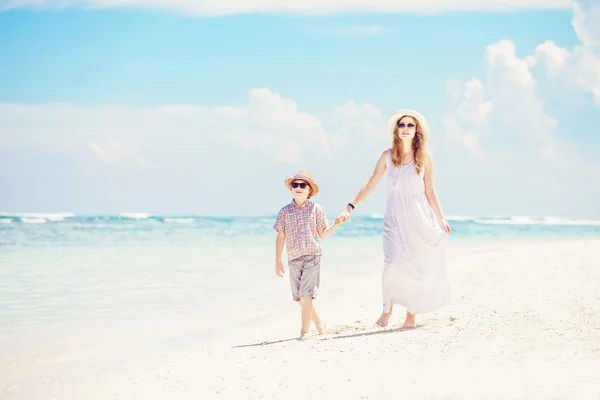 Mãe e filho caminham ao longo da praia de areia branca tendo ótimos férias em família na praia de PAndawa, Bali — Fotografia de Stock
