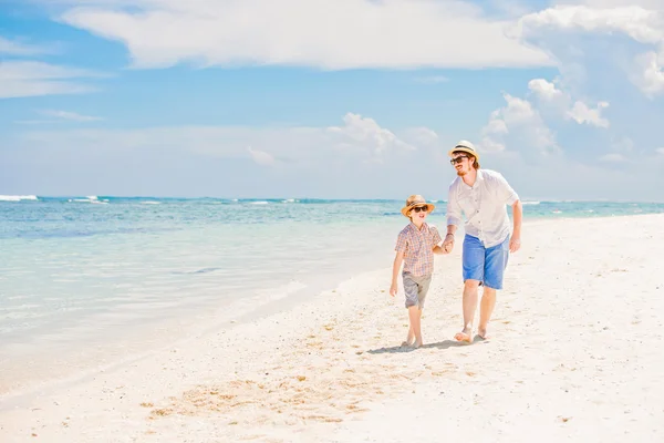 Glücklicher Vater und sein kleiner Sohn genießen im Sommerurlaub die Zeit am weißen Sandstrand am Meer — Stockfoto