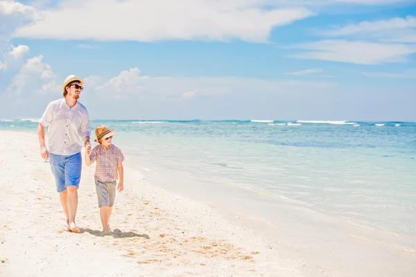 Glücklicher Vater und sein kleiner Sohn genießen im Sommerurlaub die Zeit am weißen Sandstrand am Meer — Stockfoto