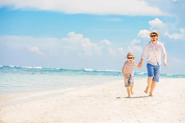 Padre con hijo corriendo descalzo en la línea de surf mar tener grandes vacaciones — Foto de Stock