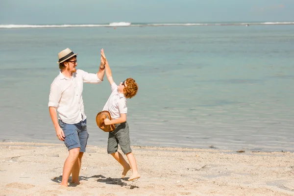 Hipster-Vater mit Bart und rothaarigem Sohn, der an einem sonnigen Tag am Strand spielt. Konzept der freundlichen Familie — Stockfoto
