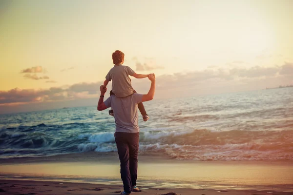 Glücklicher Vater und Sohn mit toller Zeit am Strand im Sonnenuntergang — Stockfoto