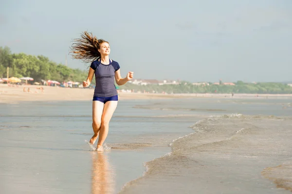 Zdrowa kobieta działa na plaży, dziewczyna robi sport odkryty, szczęśliwa kobieta ćwiczenia, fitness i zdrowia opieki koncepcja z kopia miejsce naturalny ciepły tle zachodu słońca — Zdjęcie stockowe