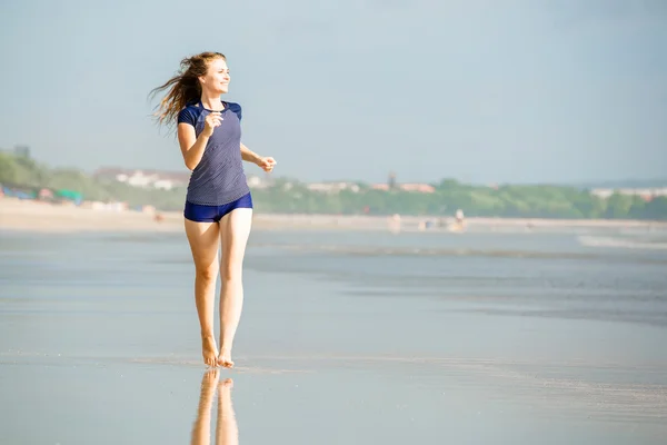 Zdrowa kobieta działa na plaży, dziewczyna robi sport odkryty, szczęśliwa kobieta ćwiczenia, fitness i zdrowia opieki koncepcja z kopia miejsce naturalny ciepły tle zachodu słońca — Zdjęcie stockowe