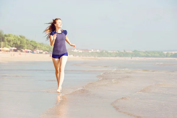 Zdrowa kobieta działa na plaży, dziewczyna robi sport odkryty, szczęśliwa kobieta ćwiczenia, fitness i zdrowia opieki koncepcja z kopia miejsce naturalny ciepły tle zachodu słońca — Zdjęcie stockowe