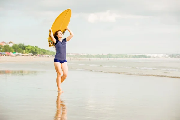 Beautiful sexy surfer girl on the beach at sunset walks along ocean shore, yellow surfboard in her hands. Healthy life, sport  concept with copyspace — Stock Photo, Image