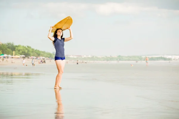 Beautiful sexy surfer girl on the beach at sunset walks along ocean shore, yellow surfboard in her hands. Healthy life, sport  concept with copyspace — Stock Photo, Image