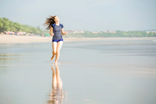 Zdrowa kobieta działa na plaży, dziewczyna robi sport odkryty, szczęśliwa kobieta ćwiczenia, fitness i zdrowia opieki koncepcja z kopia miejsce naturalny ciepły tle zachodu słońca — Zdjęcie stockowe
