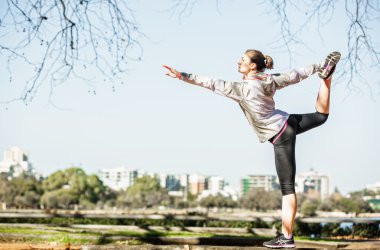 Genç kadın bankta uzanan city adlı arka plan ile sonbahar doğada koşu önce