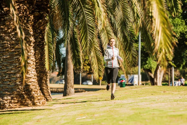 Zdrowy styl życia młodej kobiety sportowy joggingu w tropikalnym parku wzdłuż palmy Zdjęcia Stockowe bez tantiem