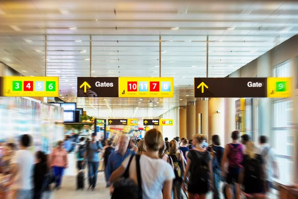 Terminal dell'aeroporto con la gente hurrieng ai cancelli — Foto Stock