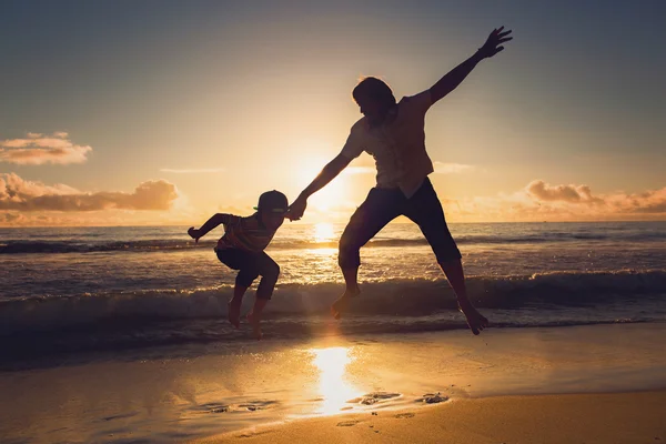 Father and son having fun together in sunset ocean on summer holidays