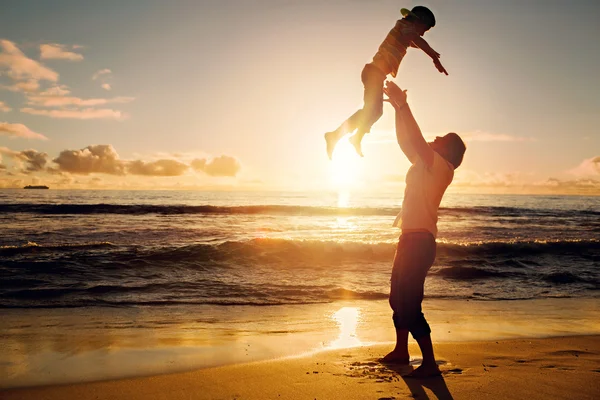 Father and son having fun together in sunset ocean on summer holidays — Stockfoto