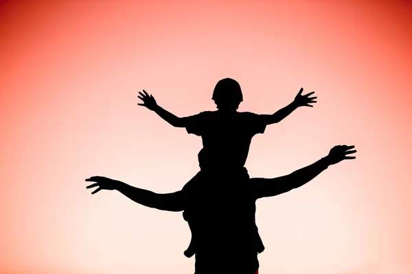 Silhouette di padre e figlio che si divertono insieme al tramonto durante le vacanze estive — Foto Stock